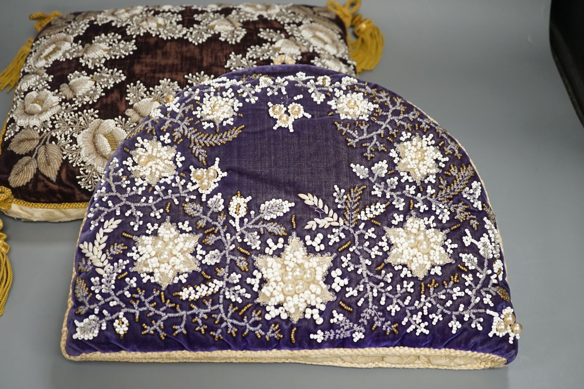 A 19th century Berlin bead worked tea cosy on purple velvet with a similar cushion, Cushion 36 cms wide x 32 high.